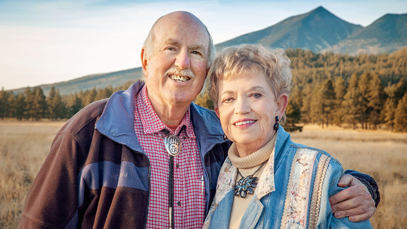 smiling man and woman outdoors in a field