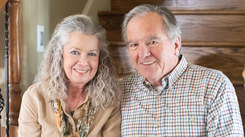 man and woman sitting on stairs smiling